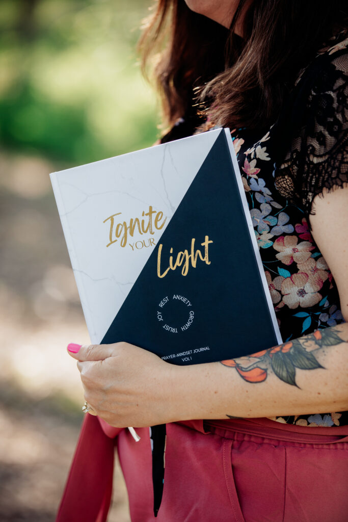 a photo of Allison Scholes holding the Ignite Your Light journal